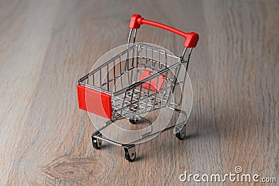 Shopping cart minimalist style. Shopping cart in the supermarket. Sale, discount, the concept of shopaholism. Stock Photo