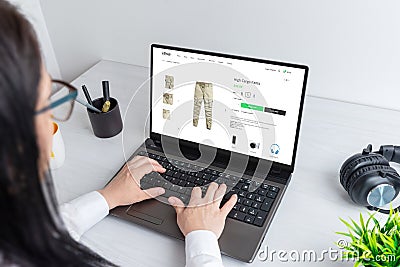 Shopping for clothes online. Woman browses cargo pants on an ecommerce website Stock Photo