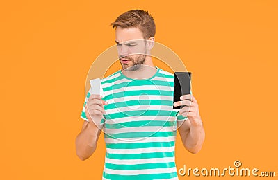 Shopping discount card. Handsome guy hold card and phone. Gift card or voucher. Cash coupon. Mobile shopping and Stock Photo