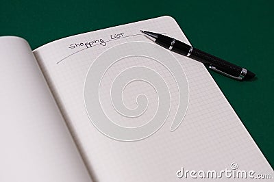 Shopping list with multiple items. Open notebook on green background Stock Photo