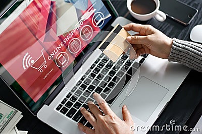 Shopping online concept. Woman holding gold credit card in hand and online shopping using on laptop at home. Stock Photo