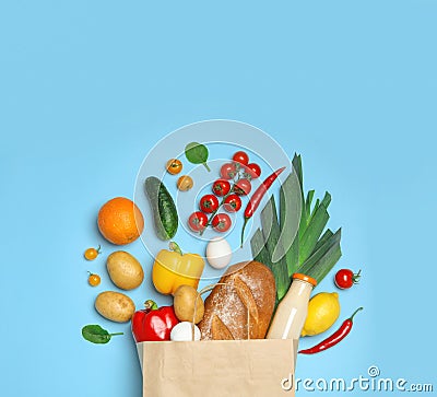 Shopping paper bag with groceries on light blue background, flat lay Stock Photo