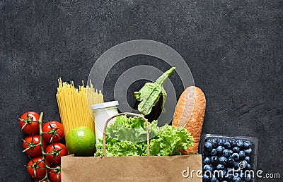 Shopping in a paper bag: vegetables, milk, berries, nuts..Food delivery. Advertising Stock Photo