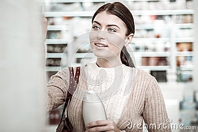 Good-looking woman smiling while shopping in pharmacy store on weekend Stock Photo