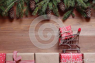 The shopping small cart with a gift on Christmas gifts on a wooden background Stock Photo