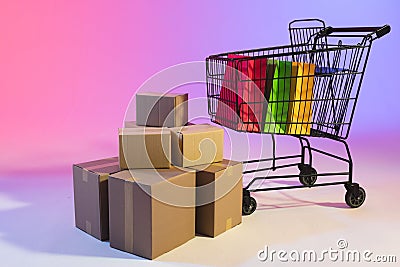 Shopping trolley with bags, boxes and copy space over neon purple background Stock Photo