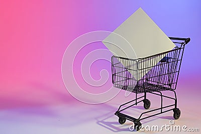 Shopping trolley with blank canvas and copy space over neon purple background Stock Photo