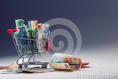 Shopping trolley full of euro money - banknotes - currency. Symbolic example of spending money in shops, or advantageous purchase Stock Photo