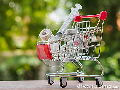 Shopping trolley with injection needle and medicine bottles. Healthy and medical concept. Stock Photo