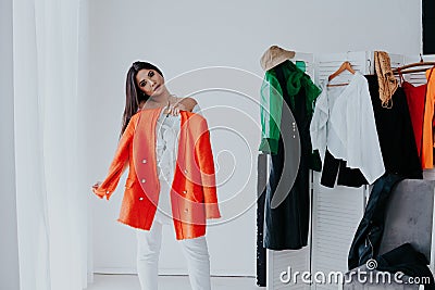 Shopping woman trying clothes. Woman choosing between summer dresses looking in mirror. Stock Photo