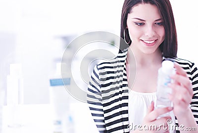 Shopping - young woman holding bottle of shampoo in supermarket Stock Photo