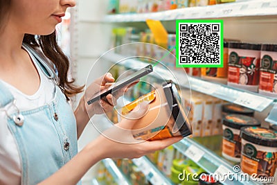 Shopping. Young woman scans qrcode of the body cream. Modern technology in everyday life. Close up Stock Photo