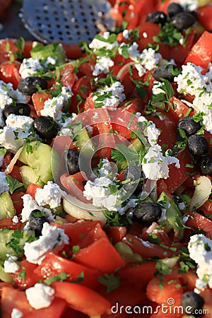 Shopska salad. Prepared from sliced tomatoes, cucumbers, roasted peppers, onion, olives, fresh parsley and grated white brined che Stock Photo