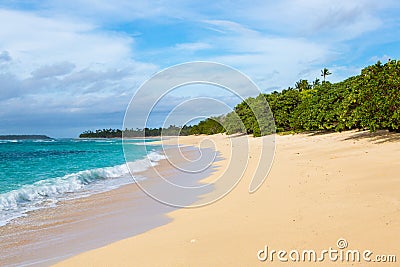 Shore of an azure, turquoise, blue lagoon. Waves, surf, swash at a remote empty idyllic sandy beach on Foa island, Haapai, Tonga. Stock Photo