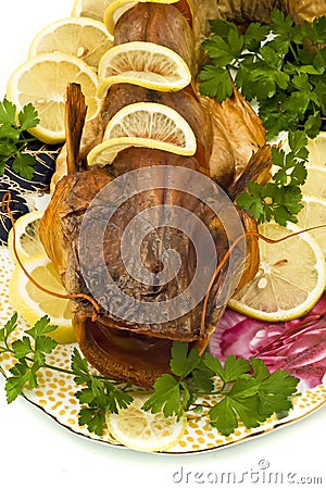 Shore dinner - smoke-dried sheatfish with lemon Stock Photo