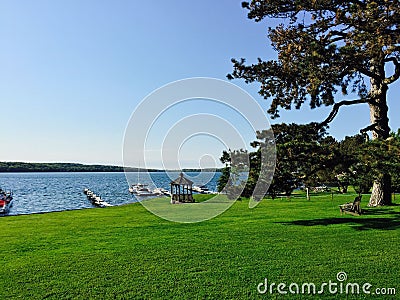 Shoreline of Skaneateles lake with anchored boats, surrounded by green vegetation, New York Stock Photo