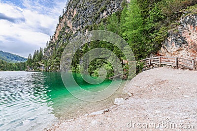 The shores of the famous Alpine Lake Braies with crystal emerald water Stock Photo