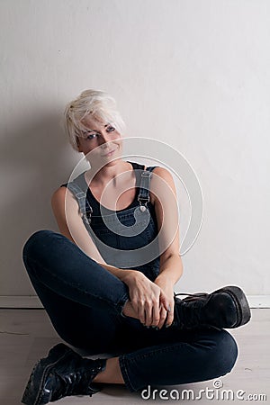 Short-haired blonde sits on the floor in the room Stock Photo