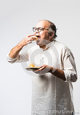 Indian old man eating phuchka, panipuri, gupchup or golgappa Stock Photo