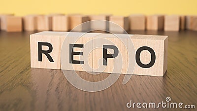 short word english letters with text - REPO - on a small wooden cubes with yellow background. copy space concept Stock Photo