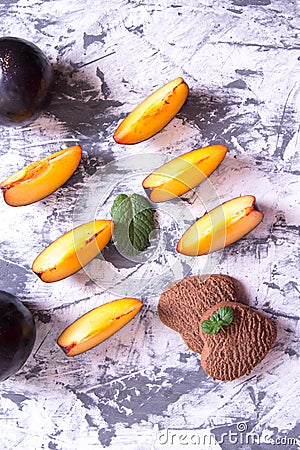 Shortbread cookies in the shape of a heart and plum slices with mint Stock Photo