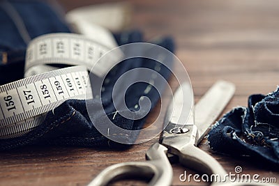 Shortening jeans. Measuring tape and tailoring scissors. Jeans cutting Stock Photo