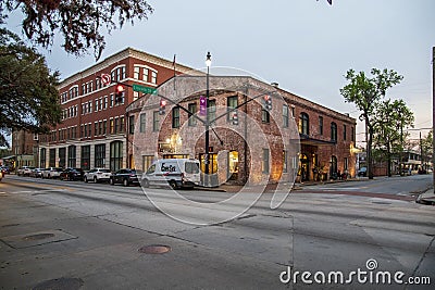 A shot along Bay Street with red brick buildings, cars on the street, people on the sidewalk, traffic signals and lush green trees Editorial Stock Photo