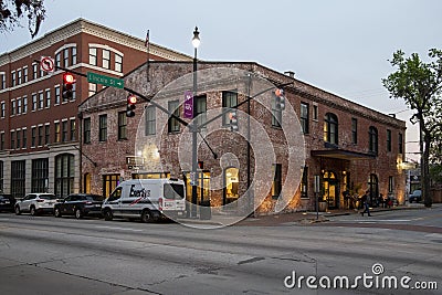 A shot along Bay Street with red brick buildings, cars on the street, people on the sidewalk, traffic signals and lush green trees Editorial Stock Photo