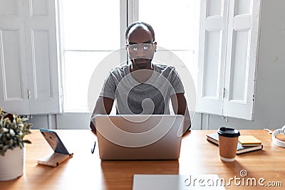 Concentrated young black business man working with laptop in the office Stock Photo