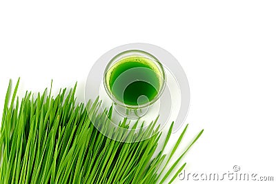 Shot of detox juice beside pile of wheat grass Stock Photo