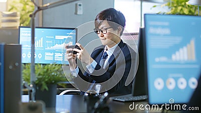 Shot of the East Asian Businessman Plaing Video Games on His Sm Stock Photo