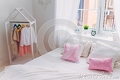 Shot of empty bedroom with no people, pink pillows, big window, alarm clock and handmade picture. Cozy interior Stock Photo