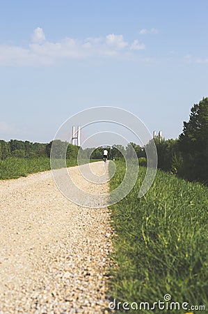 Gravel bicycle road on a sunny morning with bridge ahead Stock Photo