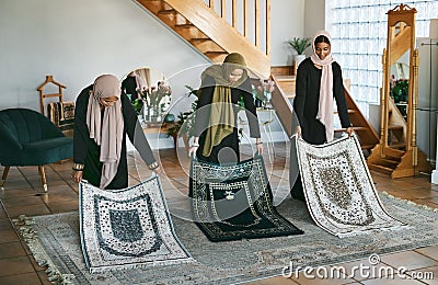 Preparation is important. Shot of a group of muslim women laying down their prayer mats in preparation. Stock Photo