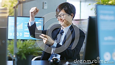 Shot of the Happy East Asian Businessman Winning in Mobile Game Stock Photo