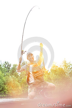 Shot of happy father catching fish at lakeshore Stock Photo