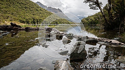 Lake in the middle of forest reflecting its surroundings Stock Photo