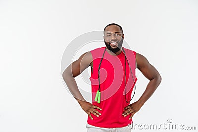 Shot of masculine man skipping rope. Muscular young man exercising with jumping rope against grey background Stock Photo