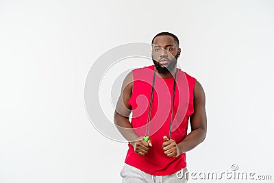 Shot of masculine man skipping rope. Muscular young man exercising with jumping rope against grey background Stock Photo