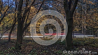 Shot of the movement of cars along the fence of the Park Stock Photo