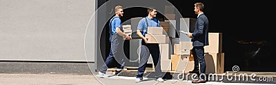 Shot of movers holding cardboard boxes Stock Photo