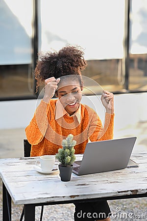 Shot of overjoyed African American woman getting mail, read good news on laptop computer Stock Photo