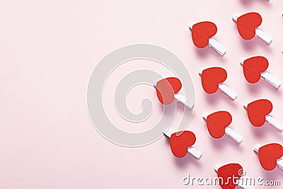 Shot of red hearts on clothespins arranged on the part of the pink background Stock Photo