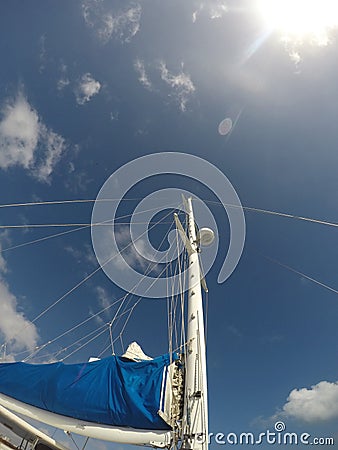 Sailboat sail detail over blue sky with bright sun Stock Photo