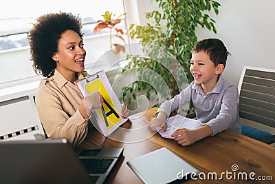 Speech therapist during a session with a little boy Stock Photo
