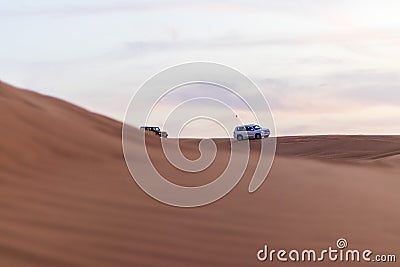 Shot of a SUV vehicle driving trough sand dunes. Desert Stock Photo