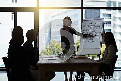 Heres what Ive come up with. Shot of a team of silhouetted businesspeople attending a meeting in the boardroom. Stock Photo