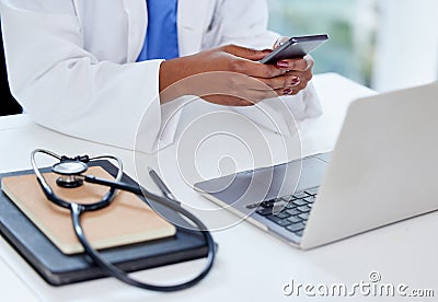 A doctor whos always busy. Shot of an unrecognizable doctor using a phone and laptop at work. Stock Photo