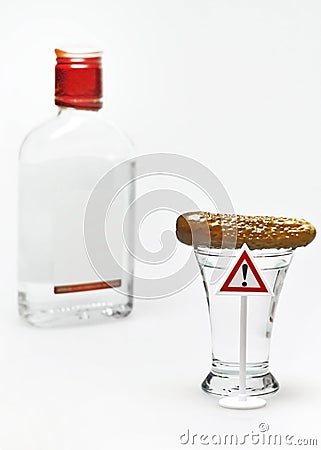 A shot of vodka with cucumber and a warning exclamation sign Stock Photo