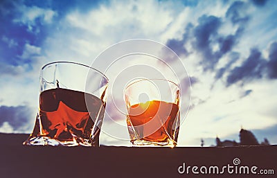 shot of whiskey at sunset dramatic sky on mountain landscape background Stock Photo